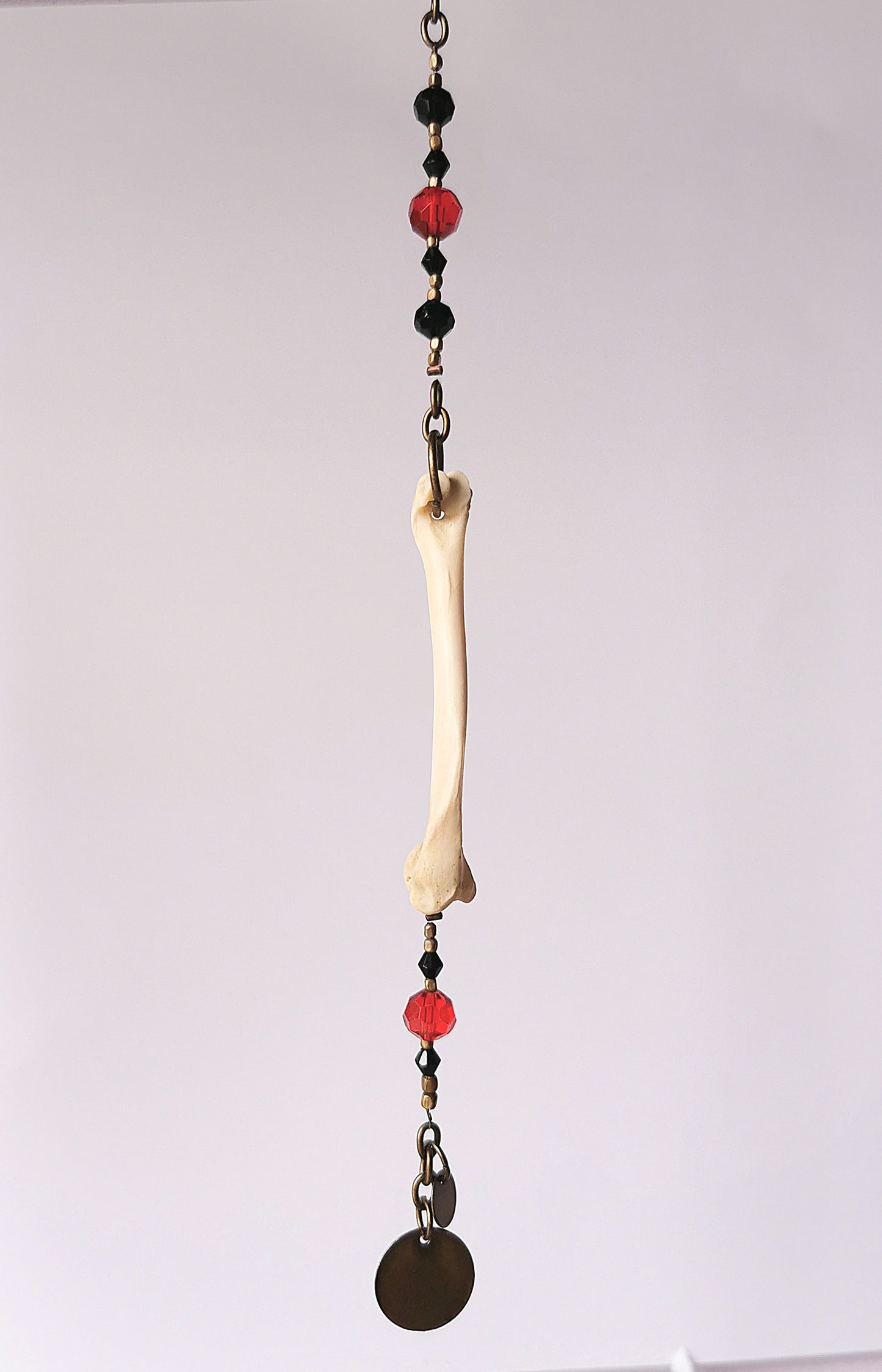 Animal bone suncatcher with red and black beads