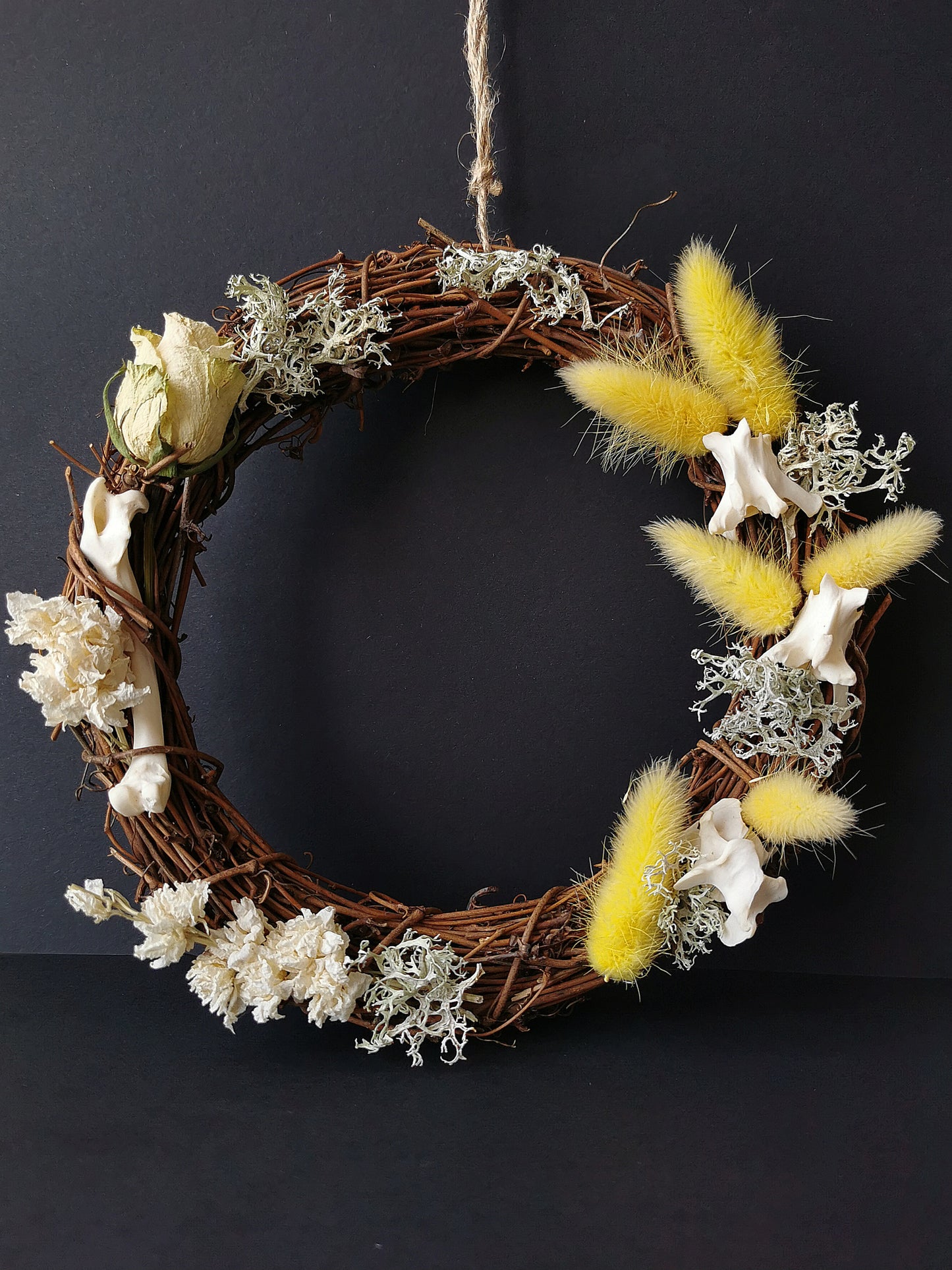 dried flower wreath with bunny tails and animal bones
