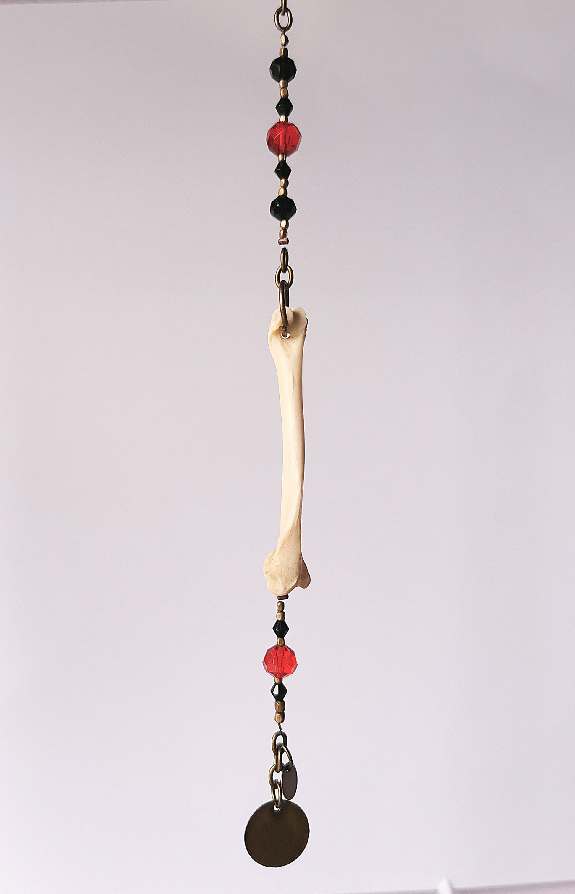 Animal bone suncatcher with red and black beads